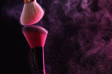 Siyah arka planda pembe göz farlı makyaj fırçaları, yakın plan. Metin için boşluk