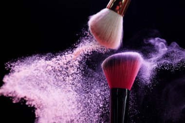 Siyah arka planda renkli göz gölgeli makyaj fırçaları, yakın plan. Metin için boşluk