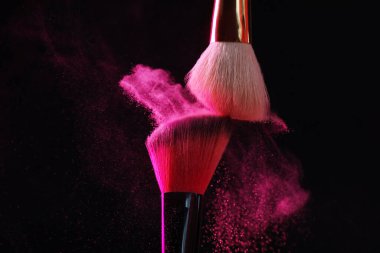 Siyah arka planda pembe göz farlı makyaj fırçaları, yakın plan