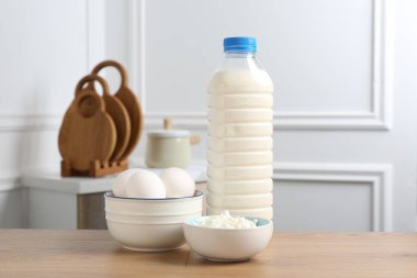 Farklı süt ürünleri ve yumurtalar ahşap masa içinde.