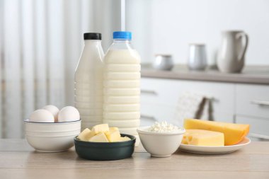 Mutfaktaki ahşap masada farklı süt ürünleri ve yumurtalar.