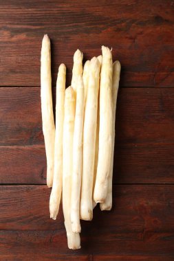 Ahşap masada bir sürü çiğ kuşkonmaz mızrağı var.