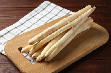 Ahşap masada çiğ kuşkonmaz mızrakları, yakın plan.