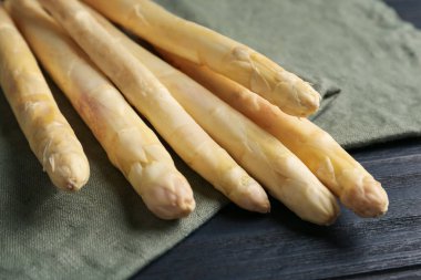 Siyah tahta masada çiğ beyaz kuşkonmaz mızrakları, yakın plan.