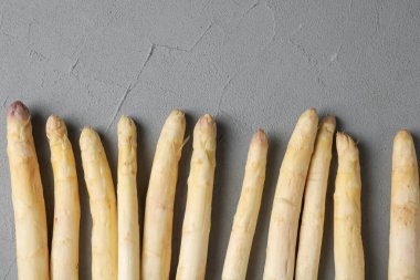 Gri desenli masa üzerinde çiğ beyaz kuşkonmaz mızrakları. Metin için boşluk