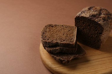 Kahverengi arka planda taze çavdar ekmeği parçaları, yakın plan. Metin için boşluk