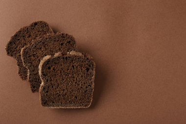 Kahverengi arka planda taze çavdar ekmeği parçaları, üst manzara. Metin için boşluk