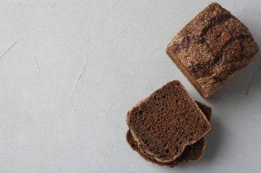 Açık gri desenli masada duran taze çavdar ekmeği parçaları. Metin için boşluk