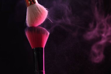 Siyah arka planda pembe göz farlı makyaj fırçaları, yakın plan. Metin için boşluk