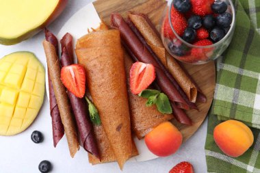 Lezzetli meyve dürümleri, nane, mango, kayısı ve böğürtlen ışık masasında, düz uzanmış