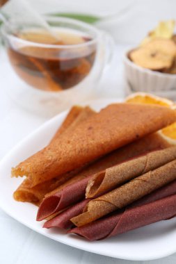 Lezzetli meyve dürümleri beyaz masada, yakın plan.