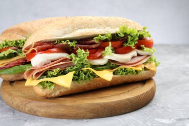 Gri desenli masada jambonlu, peynirli ve sebzeli lezzetli baget sandviçler.