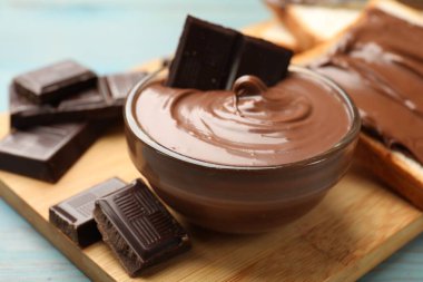 Lezzetli çikolatalı tereyağı kasede ve açık mavi ahşap masada, yakın plan