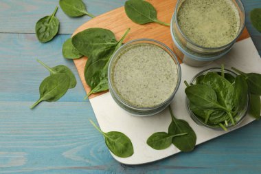 Lezzetli ıspanak püresi ve açık mavi ahşap masa üzerindeki malzemeler.