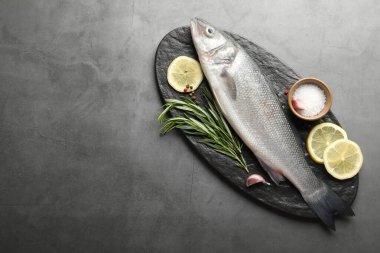 Gri masadaki baharatlı taze çiğ deniz kabuğu balığı, yazı için üst manzara ve boşluk. Deniz ürünleri lezzetleri.