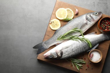 Gri masadaki baharatlı taze çiğ deniz kabuğu balığı, yazı için üst manzara ve boşluk. Deniz ürünleri lezzetleri.