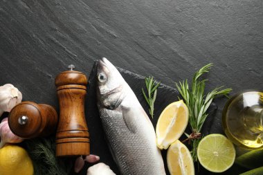 Siyah masadaki baharatlı taze çiğ deniz kabuğu balığı, düzlük ve yazı için boşluk. Deniz ürünleri lezzetleri.