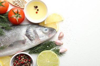 Beyaz masadaki baharatlı taze çiğ deniz kabuğu balığı, yazı için düzlük ve boşluk. Deniz ürünleri lezzetleri.