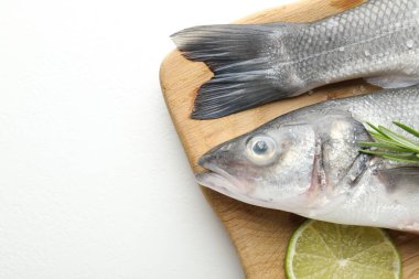 Beyaz masadaki baharatlı taze çiğ deniz kabuğu balığı, üst manzara ve yazı için yer. Deniz ürünleri lezzetleri.
