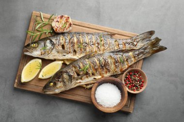 Gri masada biberiye ve limonla servis edilen lezzetli kavrulmuş deniz kabuğu balığı. Ev yapımı deniz ürünleri yemeği.