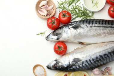Deniz ürünleri lezzetleri. Taze çiğ uskumrular ve baharatlar beyaz masada, düz yerde. Metin için boşluk