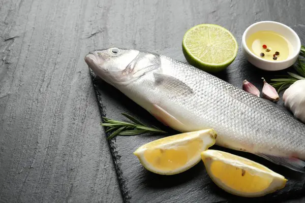 Siyah masada baharatlı taze çiğ deniz kabuğu, yakın plan. Balık ve deniz ürünleri lezzetleri