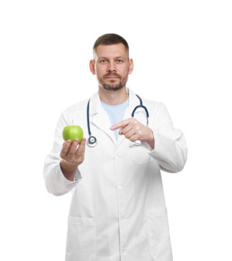 Beyaz arka planda yeşil elmalı ve steteskoplu beslenme uzmanı.