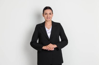 Hafif arka planda takım elbiseli kendine güvenen iş kadını.