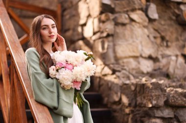 Şehir caddesinde bir buket güzel şakayığı olan çekici bir kadın. Metin için boşluk