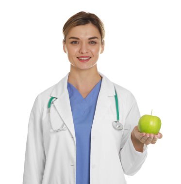 Beyaz arka planda yeşil elmalı ve steteskoplu beslenme uzmanı.