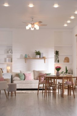 Odada rahat bir kanepe ve sandalyeli şık bir yemek masası. İç tasarım