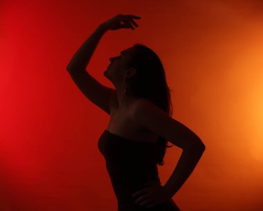 Kırmızı gradyan üzerinde poz veren kadın silueti