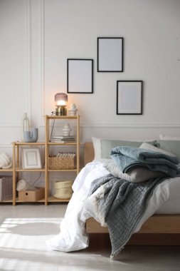 Yumuşak çarşafları olan rahat bir yatak ve şık bir odası olan bir raf. Ev tekstili