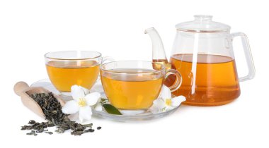 Cam fincanlarda, çaydanlıkta, çiçeklerde ve kuru yapraklarda izole edilmiş yasemin çayı.