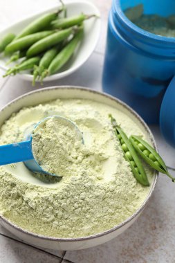 Işık döşeli masada protein tozu ve yeşil bezelyeler, yakın plan.