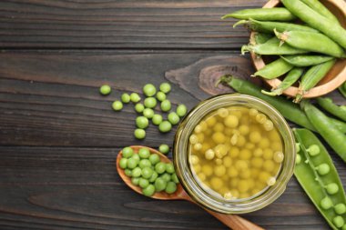 Kavanozda bezelye turşusu ve siyah ahşap masada kabuklar. Metin için boşluk
