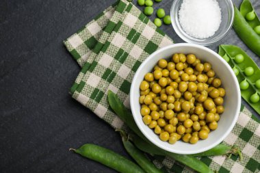 Bezelye turşusu, tuz ve kabuklar siyah masada, düz yerde. Metin için boşluk