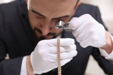 Lüks kolyeyi içeride değerlendiren, yakından gören bir eksper.