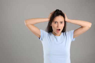 Gri arkaplanda şok olmuş bir kadının portresi, metin için boşluk