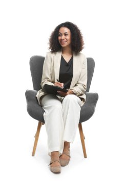 Beyaz arka plandaki koltukta pano ve kalemle profesyonel psikolog.