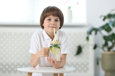 İçerideki masada limonata içen şirin bir çocuk. Tazeleyici içecek.