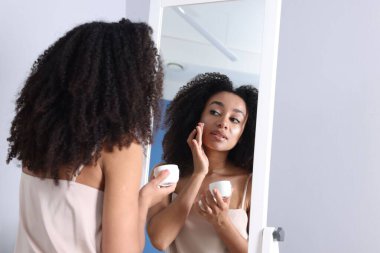 İçerideki aynaya bakan sağlıklı ciltli güzel Brezilyalı kadın.