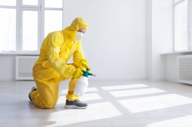 Koruyucu giysiler içinde böcek ilacı sıkan bir haşereci. Metin için boşluk