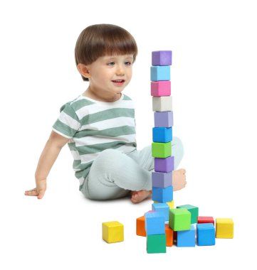Beyaz arka planda renkli küplerle oynayan sevimli küçük çocuk.