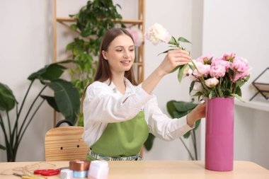 Çiçekçide şakayık buketi yapan bir çiçekçi.