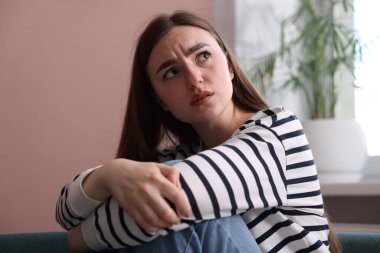 Evde paranoyadan muzdarip korkmuş bir kadın.