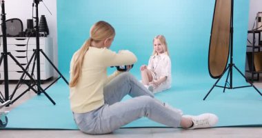 Profesyonel fotoğraf stüdyosunda modelle çalışan bir fotoğrafçı.