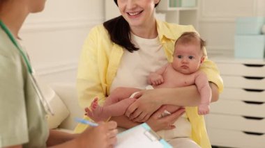 Annesi ve tatlı bebeği hastanede çocuk doktoruyla görüşüyor.