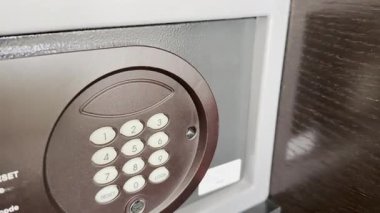 Çelik kasayı kilitlemek için tuş takımındaki düğmelere basan kadın.