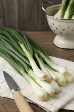 Taze taze soğan ve bıçak ahşap masada, yakın plan.